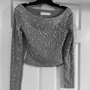 Lizette Collection stretch knit top adorned with pearls. Size Medium.